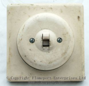 Round plastic light switch made by ROLLS Switches Ltd